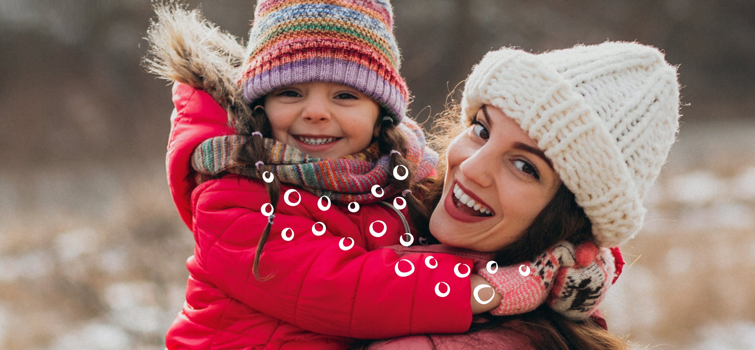 Mutter und Tochter in Winterkleidung an Fluss