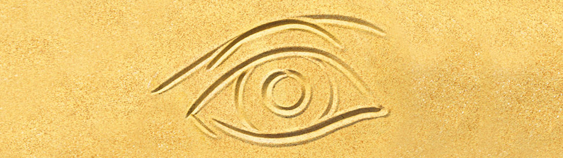 Gelber Sand in den ein Auge gezeichnet ist.