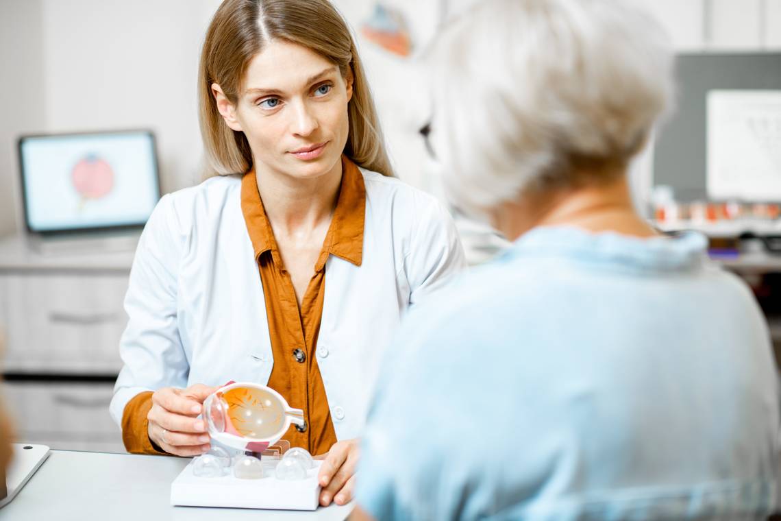 Augenärztin erklärt einer älteren Patientin etwas über das Auge. | © Adobestock