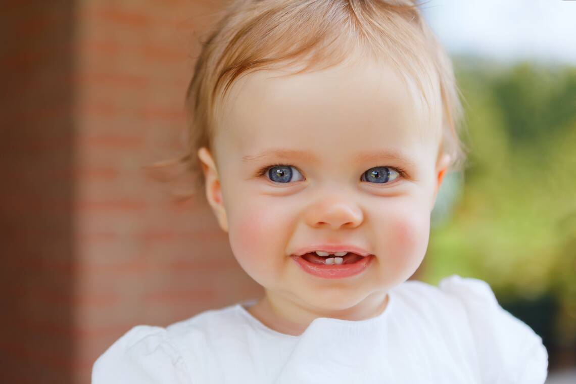 Lächelndes Kleinkind mit ersten Zähnen | © Adobe Stock
