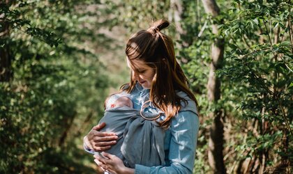Mutter trägt Baby im Tragetuch im Wald | © Kyle Nieber via Unsplash