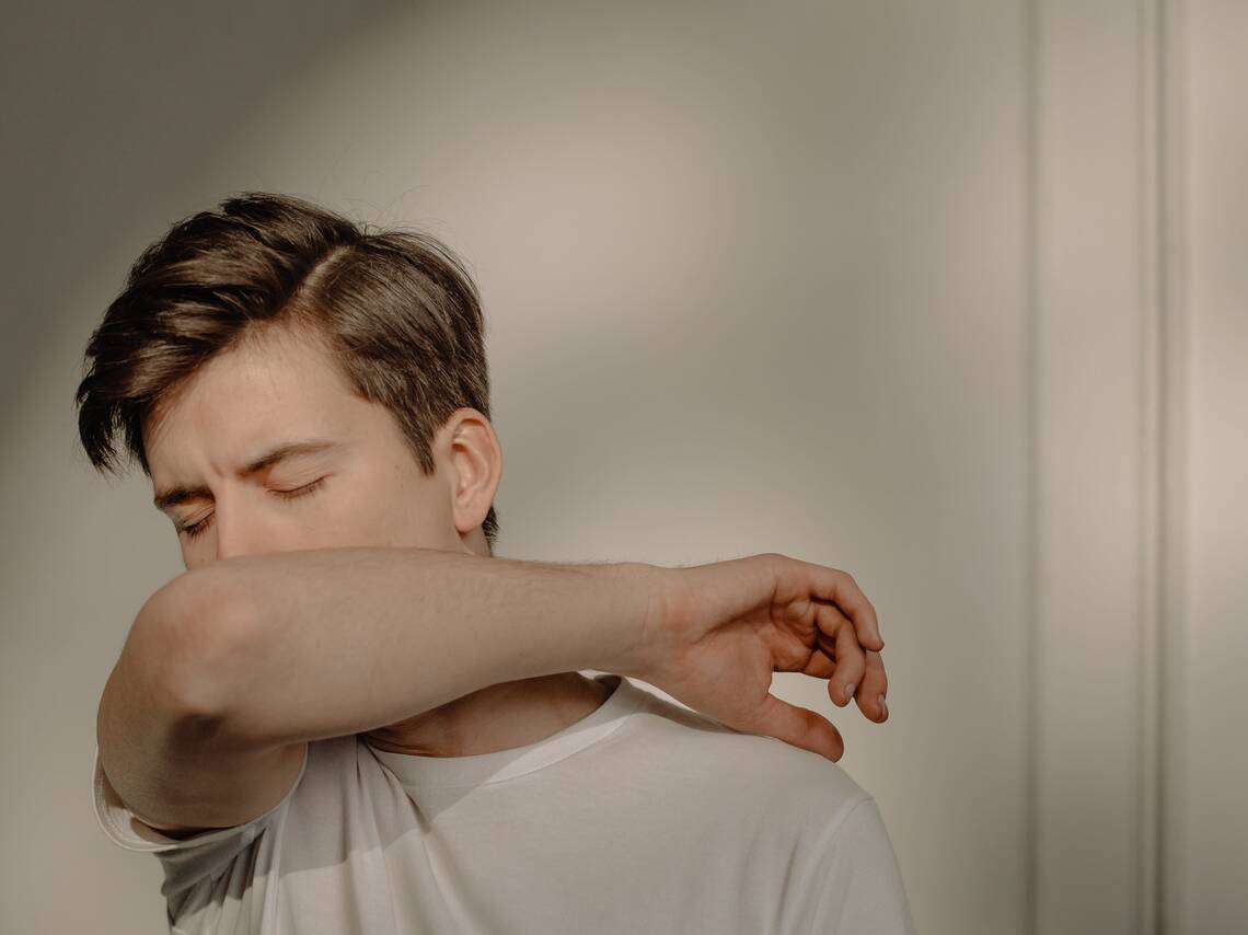 Junger Mann hustet in Armbeuge | © Cottonbro Studio via Pexels