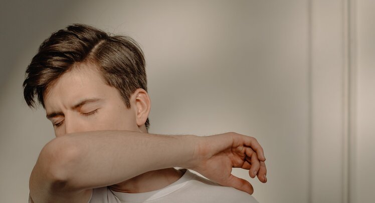 Junger Mann hustet in Armbeuge | © Cottonbro Studio via Pexels